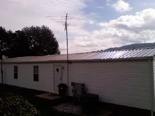 New metal roof on a single wide mobile home with a TV antenna in Loveland