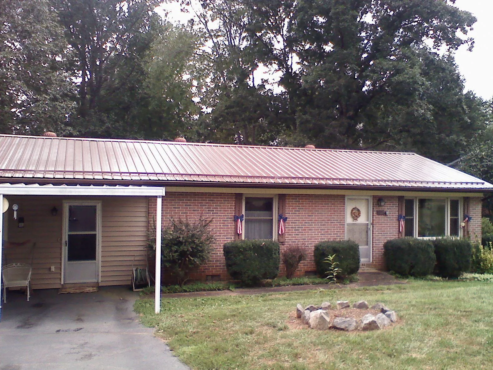 Bronze metal roof and carport on a brick ranch home — Roof Repair work by our crew in Loveland